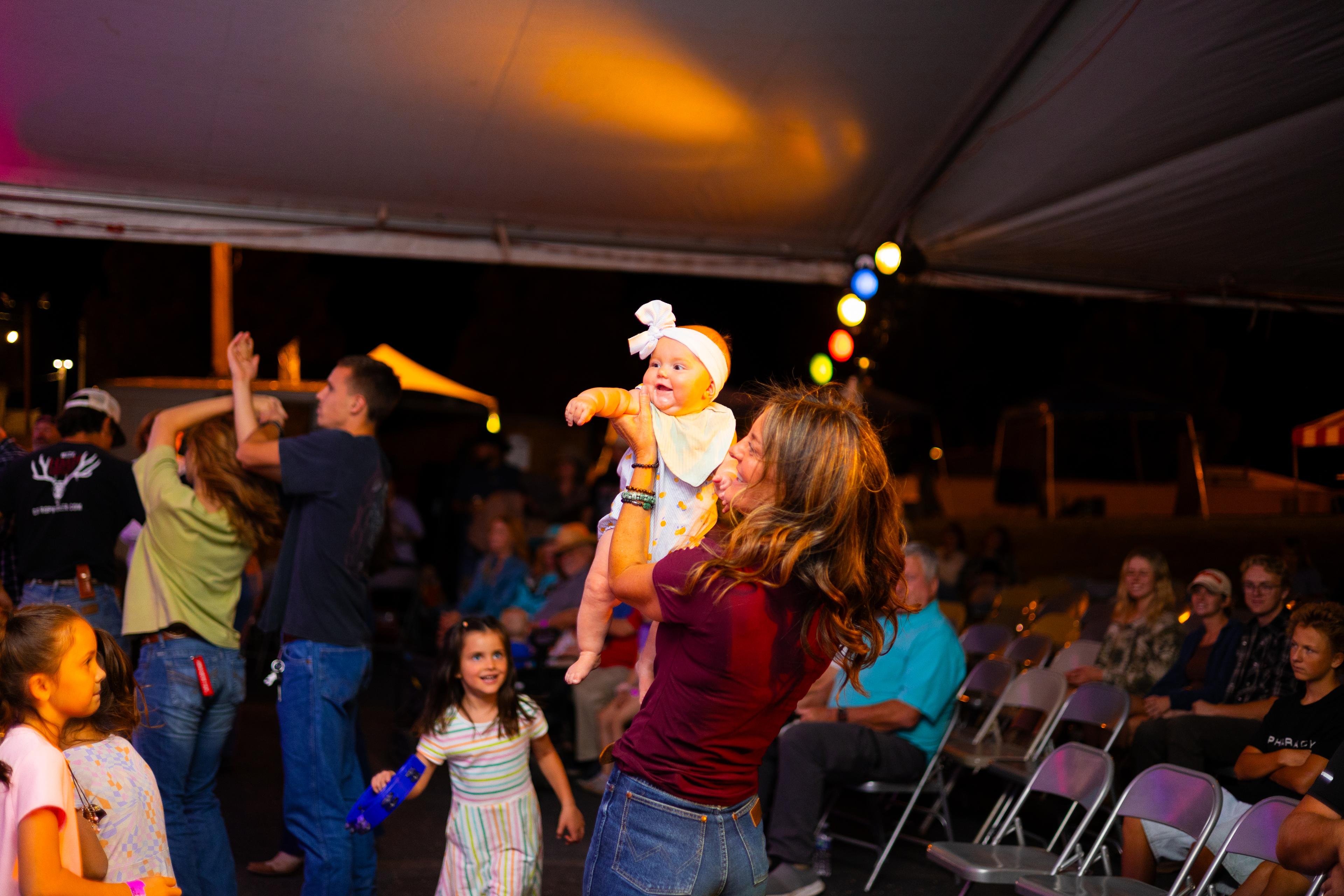 Group dancing with mom and baby in hand