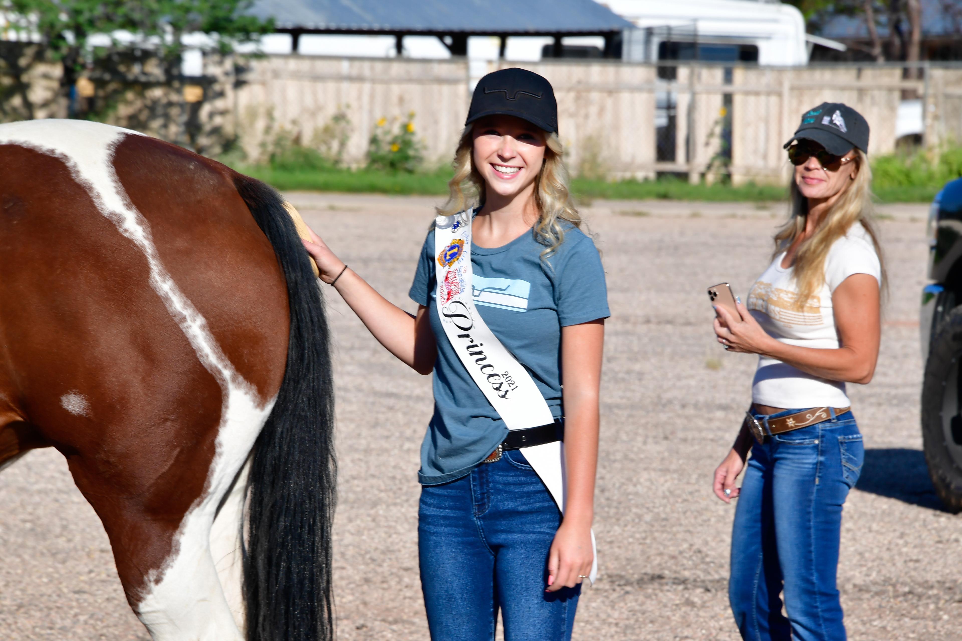2 girls standing by horse